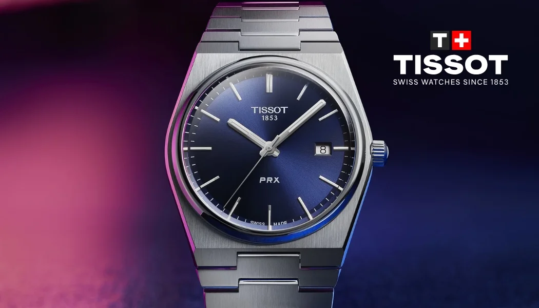 Tissot PRX quartz 40 mm blå urtavla mot blå och rosa bakgrund med Tissot logo i högra hörnet